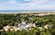 Luftfoto af Camping Demoiselles Plage feriepark i Pays de la Loire, Frankrig, tæt på skov og strand.