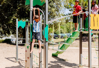 Bambini giocano su un parco giochi a Camping Demoiselles Plage, villaggio vacanze in Pays de la Loire, Francia.