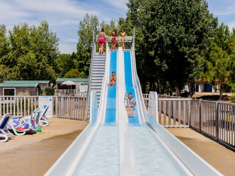 Children playing on a waterslide at Camping Demoiselles Plage, Pays de la Loire, France.