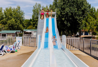 Children playing on a waterslide at Camping Demoiselles Plage, Pays de la Loire, France.