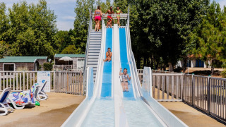 Bambini si divertono su uno scivolo d'acqua al Camping Demoiselles Plage, Pays de la Loire, Francia.