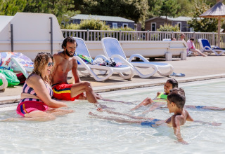 Familie amuseert zich samen in het zwembad van Camping Demoiselles Plage, vakantiepark in Pays de la Loire, Frankrijk.