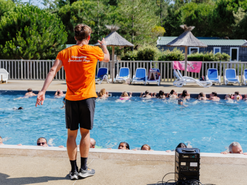 Een begeleider geeft zwembadactiviteiten op Camping Demoiselles Plage, Pays de la Loire, Frankrijk.