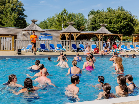 Guests participate in water aerobics in the pool at Camping Demoiselles Plage in Pays de la Loire, France.