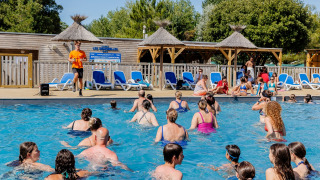 Vakantiegangers nemen deel aan aquagym in het zwembad van Camping Demoiselles Plage in Pays de la Loire, Frankrijk.
