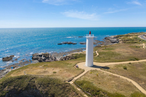 Aerial view of a lighthouse by the coast near Saint-Hilaire-de-Riez, Pays de la Loire, France, on a sunny day.