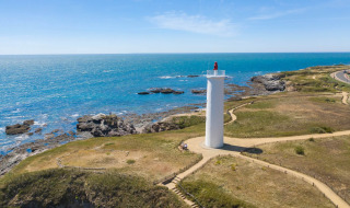 Aerial view of a lighthouse by the coast near Saint-Hilaire-de-Riez, Pays de la Loire, France, on a sunny day.