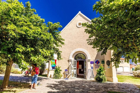 Tourist office building in Saint-Hilaire-de-Riez, Pays de la Loire, France, surrounded by trees and visitors.