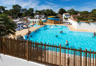 Families enjoy the swimming pool and water slide at Flower Camping Les Dunes in Pays de la Loire, France.