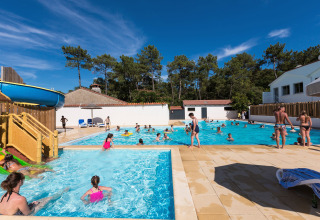 Piscina all'aperto con scivolo e famiglie al Flower Camping Les Dunes, Pays de la Loire, Francia.