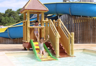 Kinder spielen an einer Wasserrutsche im Flower Camping Les Dunes in Pays de la Loire, Frankreich.