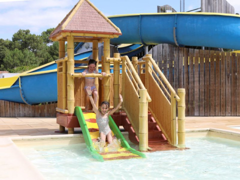 Kinder spielen an einer Wasserrutsche im Flower Camping Les Dunes in Pays de la Loire, Frankreich.