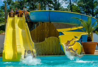 Enfants et adultes s’amusent sur les toboggans aquatiques de Flower Camping Les Dunes, Pays de la Loire, France.