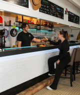 Una cliente riceve una bevanda dal barista al Flower Camping Les Dunes a Pays de la Loire, Francia.