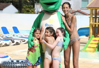 Children in swimsuits with a turtle mascot by the pool at Flower Camping Les Dunes, Pays de la Loire, France.