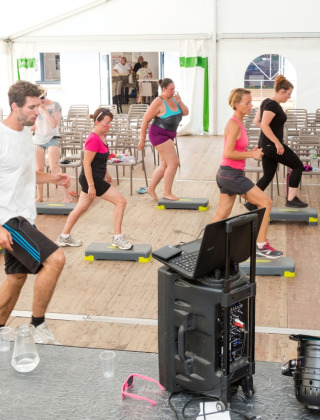 Lezione di aerobica di gruppo sotto tenda a Flower Camping Les Dunes, Pays de la Loire, Francia.
