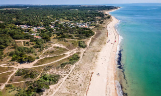 Luftfoto af den naturskønne kyst og strand nær Longeville-sur-Mer i Pays de la Loire, Frankrig, med skov og stier.