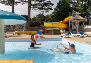 Children and adults enjoy the pool, waterslide, and sun loungers at Flower Camping Port de la Chaîne, Brittany.