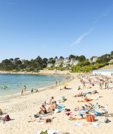 Vacanciers bronzant et nageant sur la plage du Flower Camping Port de la Chaîne en Bretagne, France.