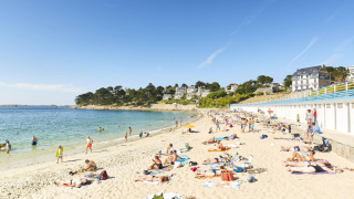 Vacanciers bronzant et nageant sur la plage du Flower Camping Port de la Chaîne en Bretagne, France.