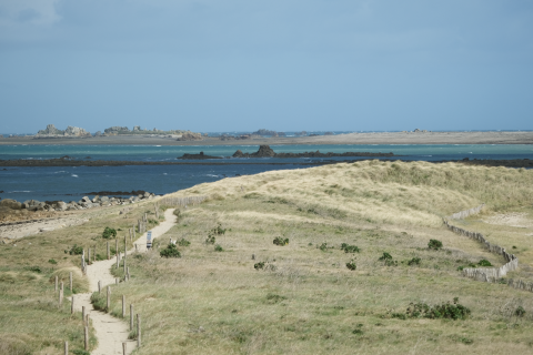 Paysage côtier près de Pleubian en Bretagne, France, avec sentiers de sable, dunes et vue sur la mer.