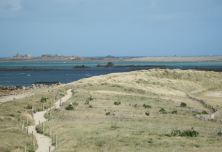 Kystlandskab nær Pleubian i Bretagne, Frankrig, med sandede stier, klitter og udsigt over havet.