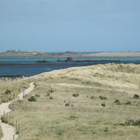 Paysage côtier près de Pleubian en Bretagne, France, avec sentiers de sable, dunes et vue sur la mer.