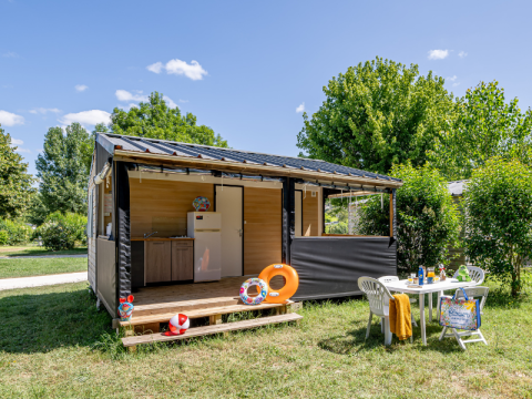 Mobitoile Standaard Hütte bei Flower Camping Les Ondines in Frankreich, mit Gartenmöbeln und Sommerdeko.