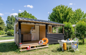 Cabaña Mobitoile Standaard en Flower Camping Les Ondines, Francia, con comedor al aire libre y césped verde.