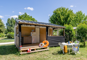 En hyggelig Mobitoile Standaard-hytte ved Flower Camping Les Ondines i Frankrig, med udendørs bord og stole.
