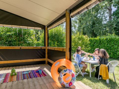 Gruppo che si gode un pasto all'aperto vicino alla cabina Mobitoile Standaard al Flower Camping Les Ondines.
