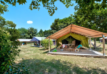 Safaritent Freeflower Standard op Flower Camping Les Ondines in Frankrijk, met gras en bomen rondom.