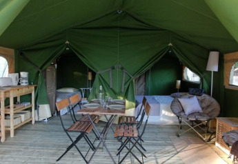 Interno della tenda safari Freeflower Standard presso Flower Camping Les Ondines con zona letto e pranzo.