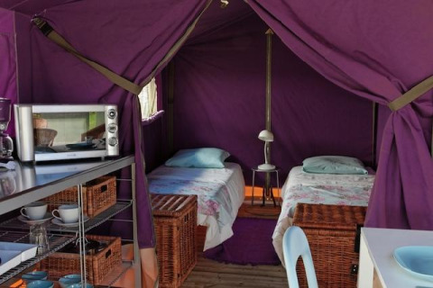Binnenkant van een Freeflower Standard safaritent bij Flower Camping Les Ondines in Frankrijk, met twee bedden.