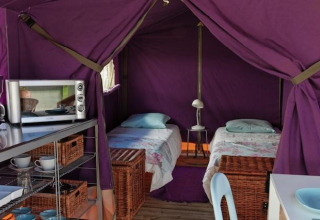 Binnenkant van een Freeflower Standard safaritent bij Flower Camping Les Ondines in Frankrijk, met twee bedden.