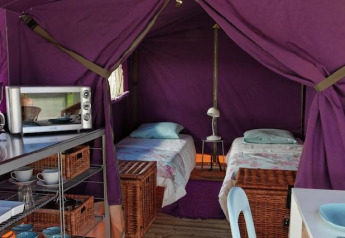 Binnenkant van een Freeflower Standard safaritent bij Flower Camping Les Ondines in Frankrijk, met twee bedden.