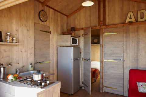 Interieur van Cabane Lodge Confort bij Flower Camping Les Ondines in Frankrijk met keuken en leefruimte.