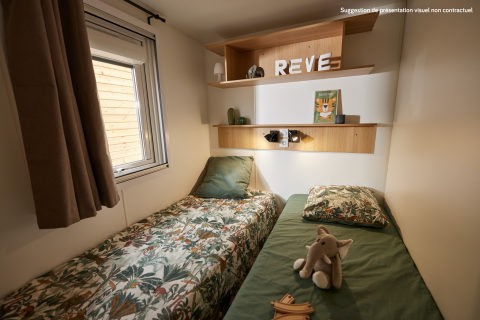 Camera da glamping accogliente con due letti singoli, finestra, mensole in legno e peluche elefante.