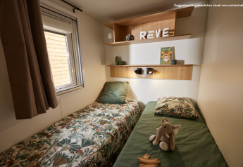 Acogedora habitación glamping con dos camas individuales, ventana, estantes de madera y peluche elefante.