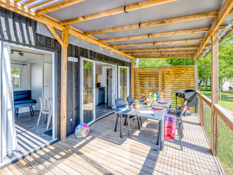 Houten terras met eetset en barbecue bij Homeflower Premium, Flower Camping Les Ondines, Frankrijk.