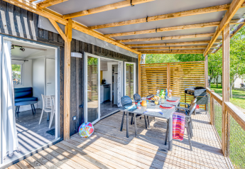 Udendørs terrasse med spisebord og grill ved Homeflower Premium-hytte på Flower Camping Les Ondines, Frankrig.