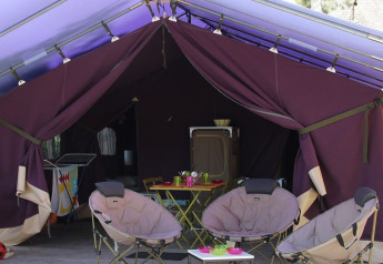 Indvendig udsigt fra et Safari-telt med campingmøbler, stole og bord på Flower Camping La Plage i Frankrig.