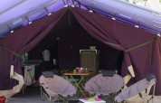 Indvendig udsigt fra et Safari-telt med campingmøbler, stole og bord på Flower Camping La Plage i Frankrig.