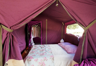 Gezellige safari tent met tweepersoonsbed en kledingrek bij Freeflower Standaard, Flower Camping La Plage, Frankrijk.