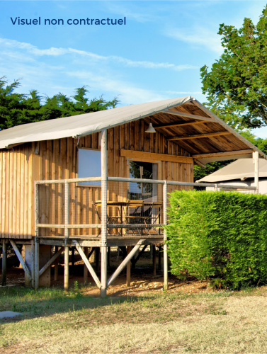 Vue extérieure de la Cabane Lodge Standaard, une cabane en bois sur pilotis avec terrasse et verdure.