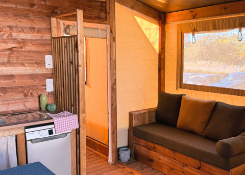 Indvendigt billede af en komfortabel safari telt Cotton Flower Canvas Lodge ved Flower Camping La Plage, Frankrig.