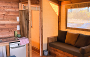 Indvendigt billede af en komfortabel safari telt Cotton Flower Canvas Lodge ved Flower Camping La Plage, Frankrig.
