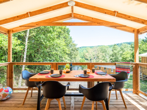 Buiten eten op het terras van Cosyflower Premium lodge bij Flower Camping La Plage in Frankrijk, omringd door groen.