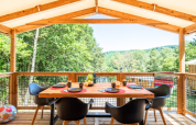 Buiten eten op het terras van Cosyflower Premium lodge bij Flower Camping La Plage in Frankrijk, omringd door groen.