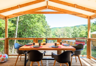 Buiten eten op het terras van Cosyflower Premium lodge bij Flower Camping La Plage in Frankrijk, omringd door groen.